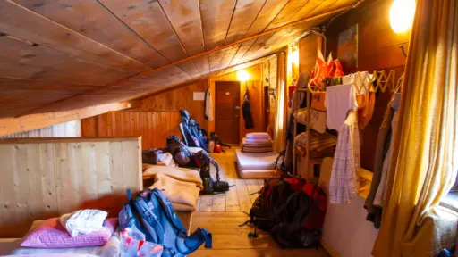 Typisches Lager auf einer Hütte Typisches Matratzenlager auf einer Alpenhütte: Lager mit Rucksäcken und zum Trocknen aufgehängter Wanderkleidung.