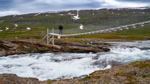 Häengebrücke im Saltfjellet-Svartisen-Nationalpark Trekking im Saltfjellet: Eine schmale Hängebrücke überquert einen reißenden Gebirgsfluss im Saltfjellet-Svartisen Nationalpark.
