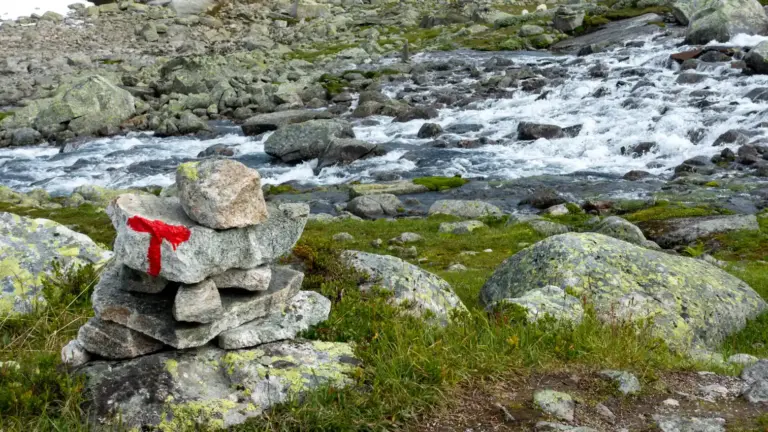 Furt mit Wegmarkierungen (rote Punkte und rotes "T") an einem Gletscherfluss des Hardangerjokulen