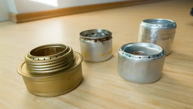 Dosenkocher vs. Trangia links ein Trangia-Spiritus-Brenner, daneben die Dosenkocher Beer-Can-Stove, Penny-Stove und Capillary Stove