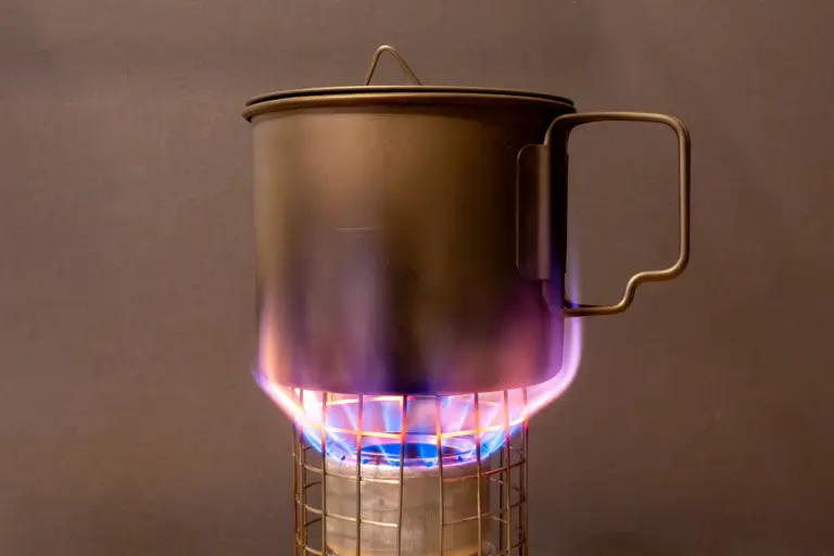 Penny-Stove mit glühendem Topfstand Penny-Stove mit glühendem Topfstand aus Drahtgitter und glühendem Topfboden. Die Flammen schlagen am Topf vorbei nach oben.