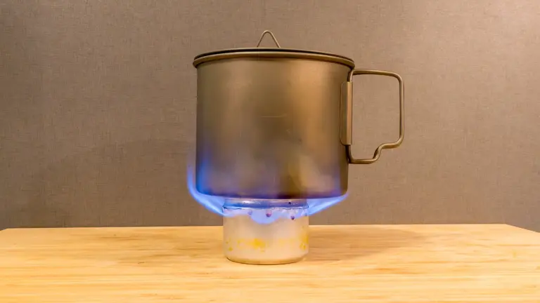 Praxistest des Beer-Can-Stove Beer-Can-Stove mit zu großem Flammenbild, Flammen schlagen bei einem warmen Kocher seitlich am Topf hoch.
