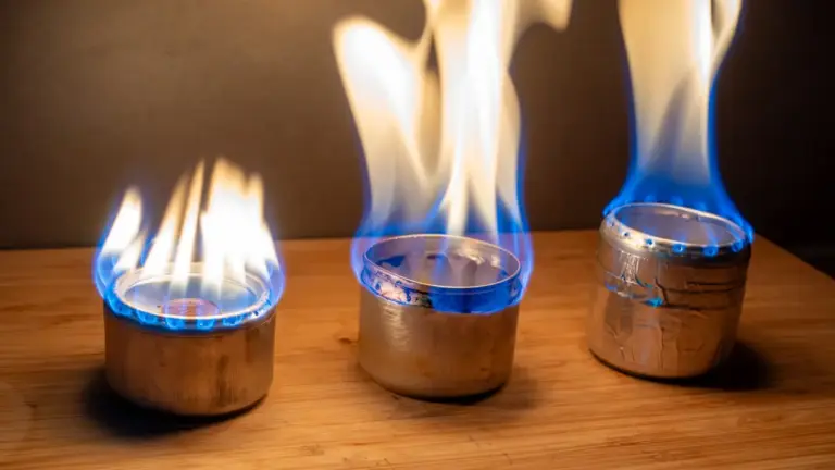 Dosenkocher-Vergleich: Drei Eigenbau-Spirituskocher im Betrieb 3 gezündete Dosenkocher im Vergleich v.l.n.R.: Penny Stove (unkontrollietre Flamme), Beer Can Stove (breiteste Flamme), Capillary Stove (effizienteste und gleichmäßigste Flamme)