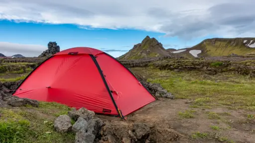 Leichtes Trekkingzelt in Berglandschaft Islands Rotes Trekkingzelt (Hilleberg Unna) in rauer Berglandschaft Islands – typisches Setup für eine Trekkingtour mit leichtem aber robustem Zelt