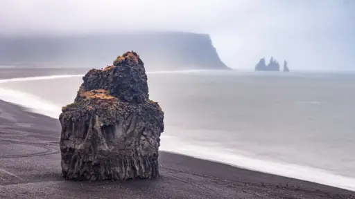 Reynisfjara – schwarzer Strand Reynisfjara - schwarzer Strand - hier von oben mit großem Basalfels, weitem schwarzen Strand und Vik im Hintergrund