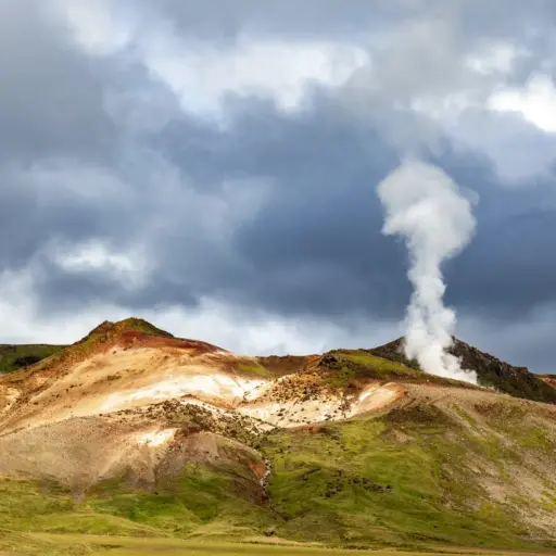 Geothermalgebiet Krýsuvík – Dampfende Fumarolen in Seltún, Island Dampfende Fumarole in der Hügellandschaft des Krýsuvík-Geothermalgebiets in Island unter einem bewölkten Himmel.