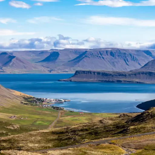 Westfjorde Island Blick in den Wetfjorden auf einen Fjord, klein zu sehen: das Fischerdorf Bolungarvík
