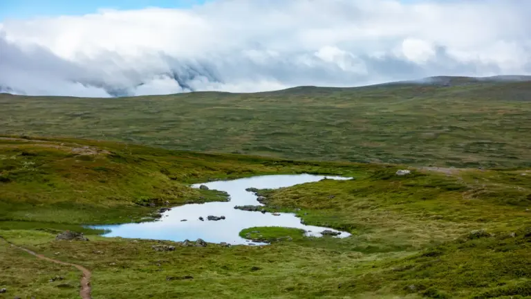 Jämtlandsfjällen bei Hulke Jämtlandsfjällen bei Hulke - ein kleiner See in dem sich der dramatische Wolkenhimmel spiegelt, weites Fjell und ein schmaler Wanderweg