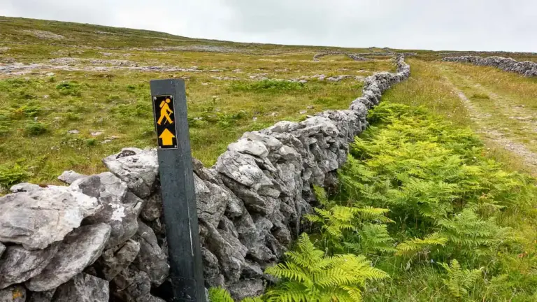 Wegmarkierung auf dem Burren Way Wegmarkierung auf dem Burren Way - ein kleines gebes Männchen mit Richtungspfeil