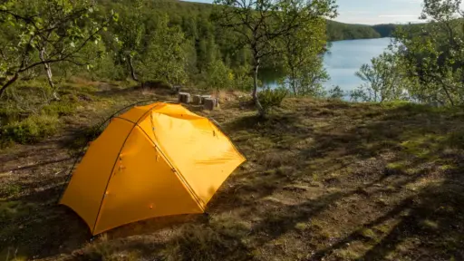 Zelten in Finnland gelbes Zelt oberhalb eines Sees im Wald in Finnland
